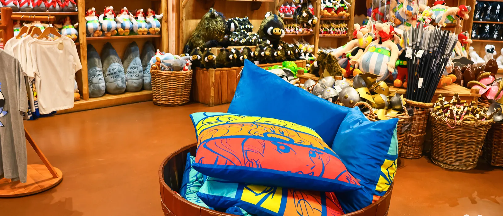 Intérieur de la boutique Le Grand Marché de Lutèce, tonneau garni de coussins bleus imprimés et rayonnages de peluches