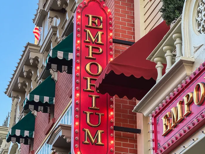 Enseigne verticale rouge et or de l’Emporium sur les façades de Main Street U.S.A.