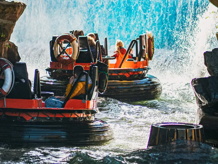 Bouées orange passant sous un pont de bois sculpté près d’une cascade à Europa-Park.