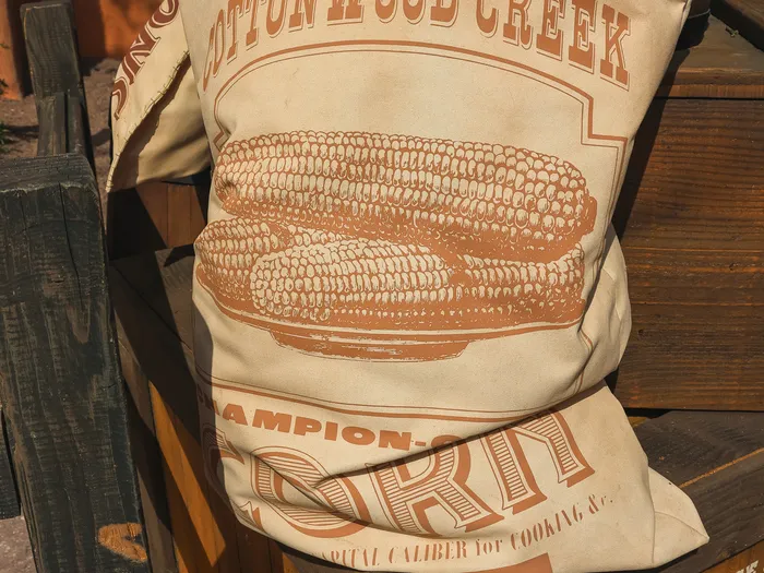Sacs de toile décoratifs Cottonwood Creek Champion Corn posés sur des caisses en bois à l’Overland Trail Cafe