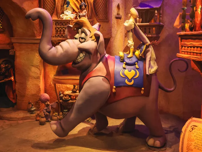 Scène animée d’un éléphant portant Aladdin devant un décor de souk au Passage Enchanté d’Aladdin