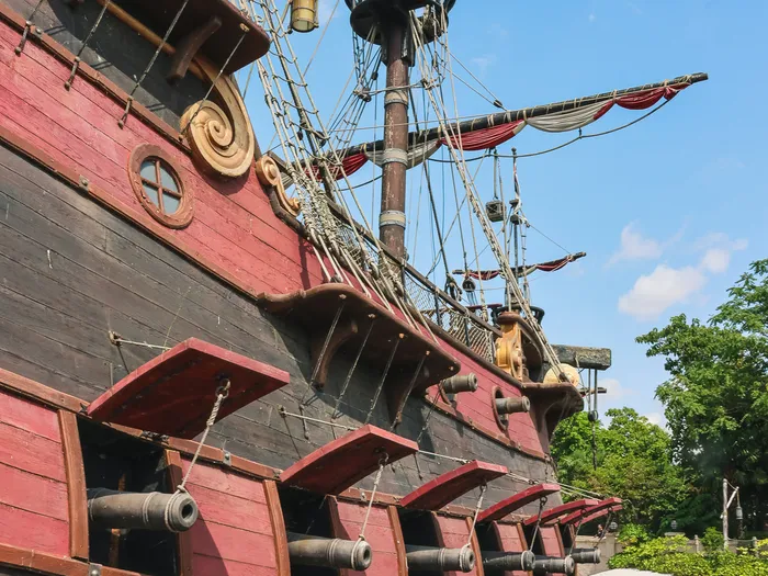 Coque à canons et mâts gréés du galion des pirates se dressant vers le ciel bleu à Adventureland.