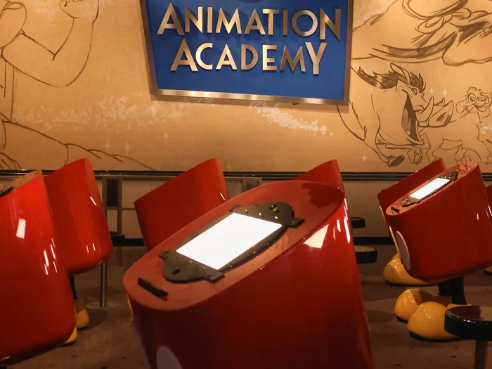 Enseigne Animation Academy et pupitres à dessin rouges éclairés