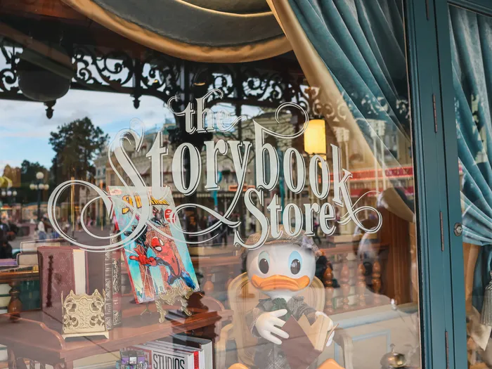 Etched window of The Storybook Store with a Donald figure and books on display