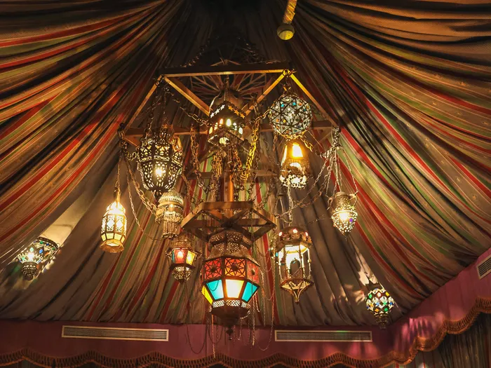 Plafond drapé de tissus rayés et lustre couvert de lanternes orientales à l’Agrabah Café