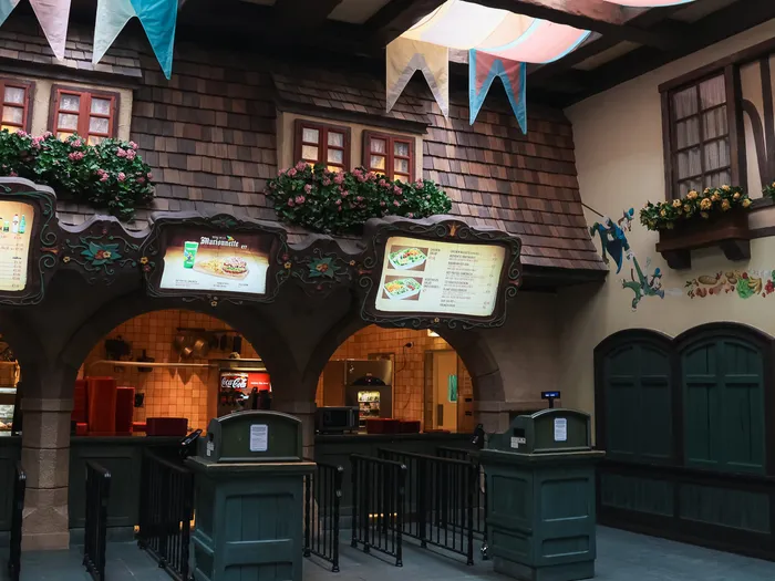 Comptoir de commande et menus sous les arches du restaurant Au Chalet de la Marionnette, à Fantasyland.