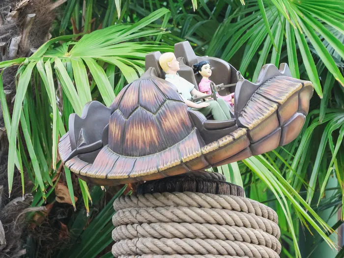 Wagon en forme de carapace de tortue de Crush’s Coaster surplombant des palmiers, Worlds of Pixar