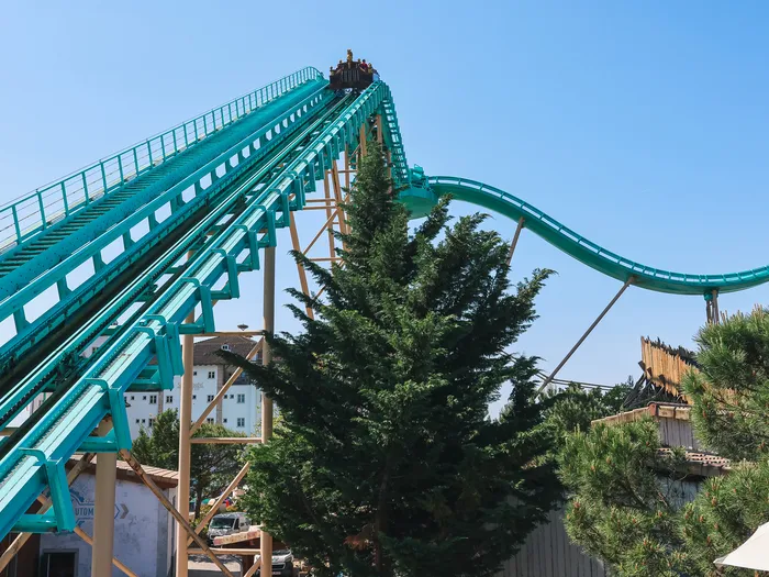 Voie verte d’un coaster aquatique montant vers le sommet, derrière un sapin, à Europa-Park.