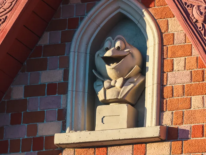Buste sculpté du crapaud dans une niche ogivale, façade brique de Toad Hall Restaurant