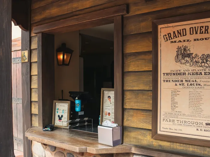 Comptoir de commande en bois et grande affiche western Grand Overland Mail Route à l’Overland Trail Cafe, Frontierland