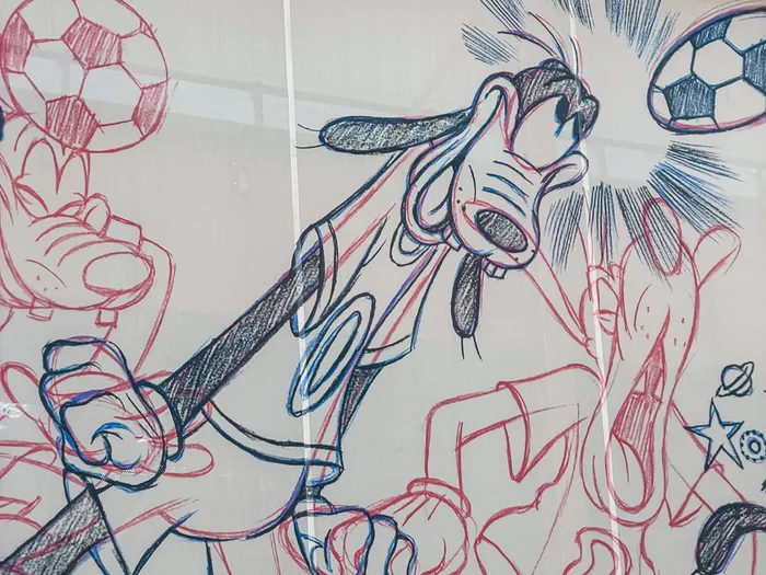 Fresque murale façon croquis de Dingo jouant au football sur la façade du Sports Bar & Lounge, Disney Village.