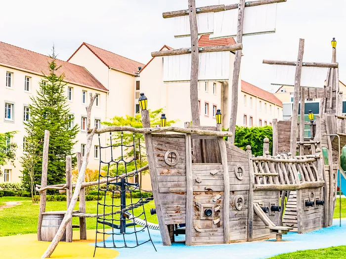 Grande aire de jeux en bois en forme de galion pirate devant l’Explorers Hotel Disney.