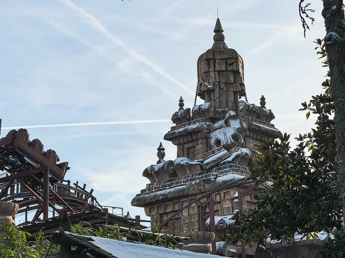 Tour du temple et rails rouillés d’Indiana Jones and the Temple of Peril sous la neige, à Adventureland.