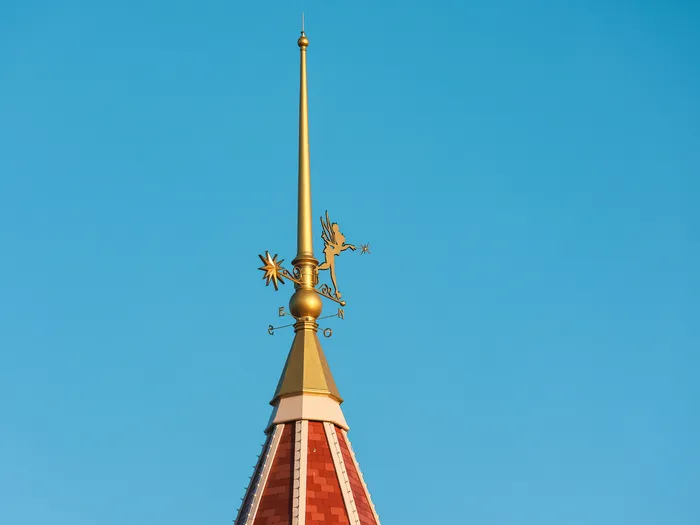 Statue dorée de la fée Clochette au sommet d’une flèche du toit du Disneyland Hotel.