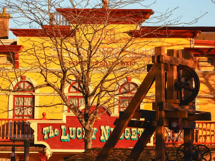 Façade jaune et rouge du Lucky Nugget Saloon à Frontierland, baignée par la lumière du soir.