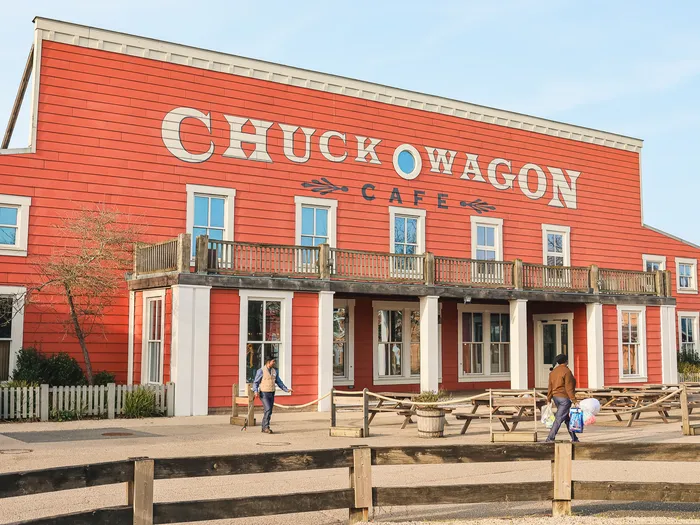 Façade rouge western du Chuck Wagon Café à l’hôtel Cheyenne, tables de pique-nique et visiteurs devant