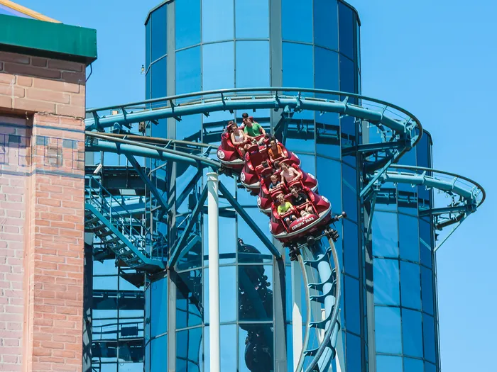 Wagons rouges de l’Euro-Mir plongeant sur les rails devant une tour miroir à Europa-Park