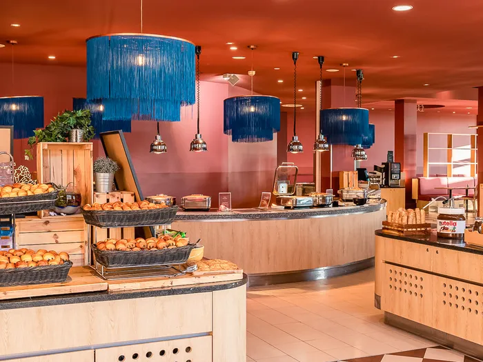 Buffet du petit-déjeuner du Grand Magic Hotel avec viennoiseries et suspensions bleues à franges
