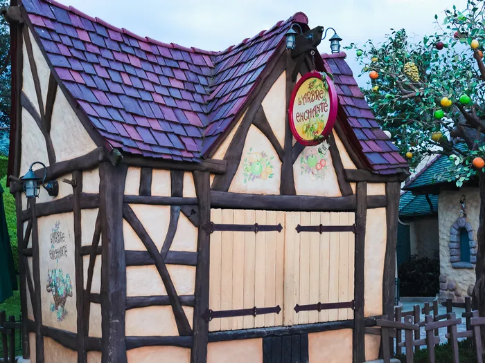 Kiosque à colombages de L'Arbre Enchanté avec enseigne ronde et arbre à agrumes coloré à Fantasyland