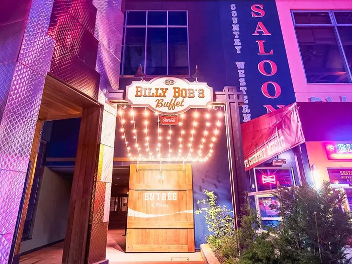 Façade illuminée au néon du Billy Bob’s Buffet le soir, avec son enseigne Saloon country western au Disney Village