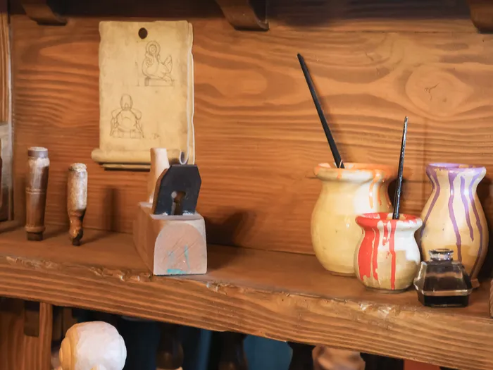Étagère d’atelier avec outils de sculpture, croquis et pots de peinture, décor des Voyages de Pinocchio