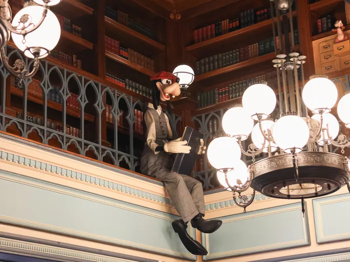 Goofy figure sitting next to a chandelier and bookcases in The Storybook Store