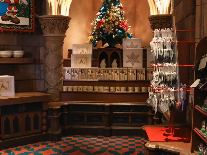 Intérieur de La Boutique du Château à Disneyland Paris, décoré pour Noël, avec son sol carrelé et son sapin.