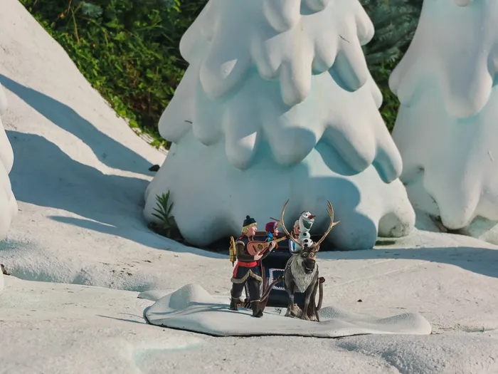 Figurines de Kristoff, Anna, Olaf et Sven sur un traîneau parmi les sapins enneigés miniatures au Pays des Contes de Fées