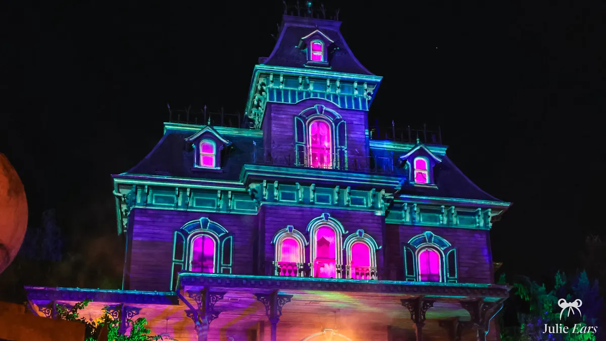 Phantom Manor lit in purple and pink at night during the Halloween party at Disneyland Paris