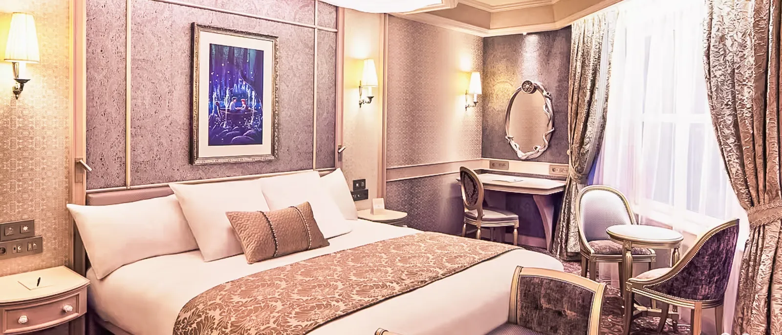 Chambre du Disneyland Hotel aux tons rosés, grand lit, coiffeuse à miroir et fauteuils près de la fenêtre.