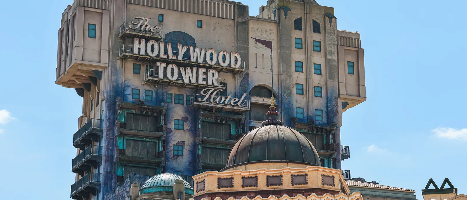 La tour délabrée du Hollywood Tower Hotel et son enseigne lumineuse dominent le ciel, au Parc Disney Adventure World.