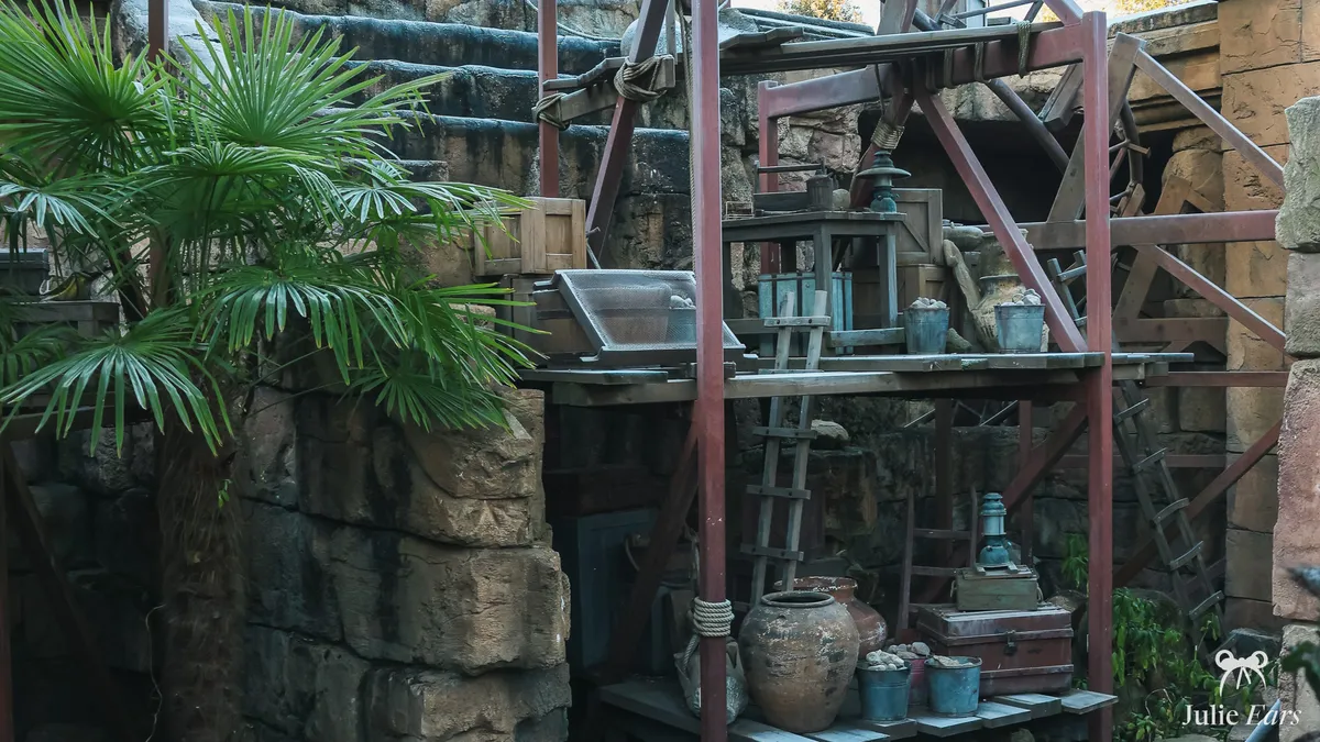 Excavation site at the foot of the Indiana Jones temple in Adventureland: wooden scaffolding, clay jars, buckets, a trunk and a ladder