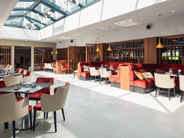 Salle du restaurant du Ki Space Hôtel & Spa, fauteuils rouges et blancs sous une grande verrière