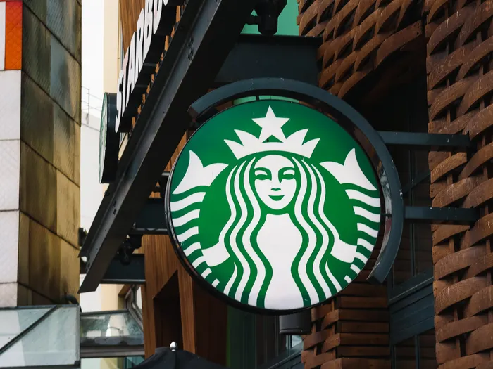 Enseigne ronde Starbucks à la sirène verte fixée sur une façade du Disney Village à Disneyland Paris