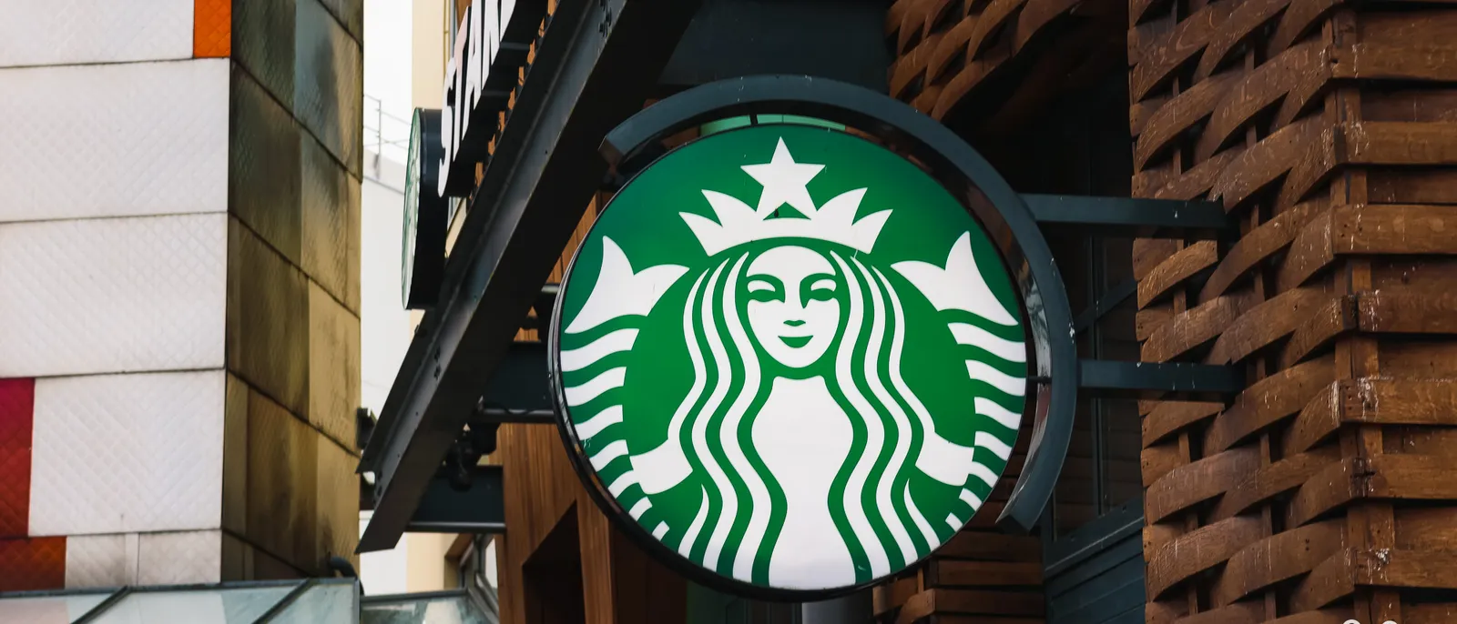 Enseigne ronde Starbucks à la sirène verte fixée sur une façade du Disney Village à Disneyland Paris