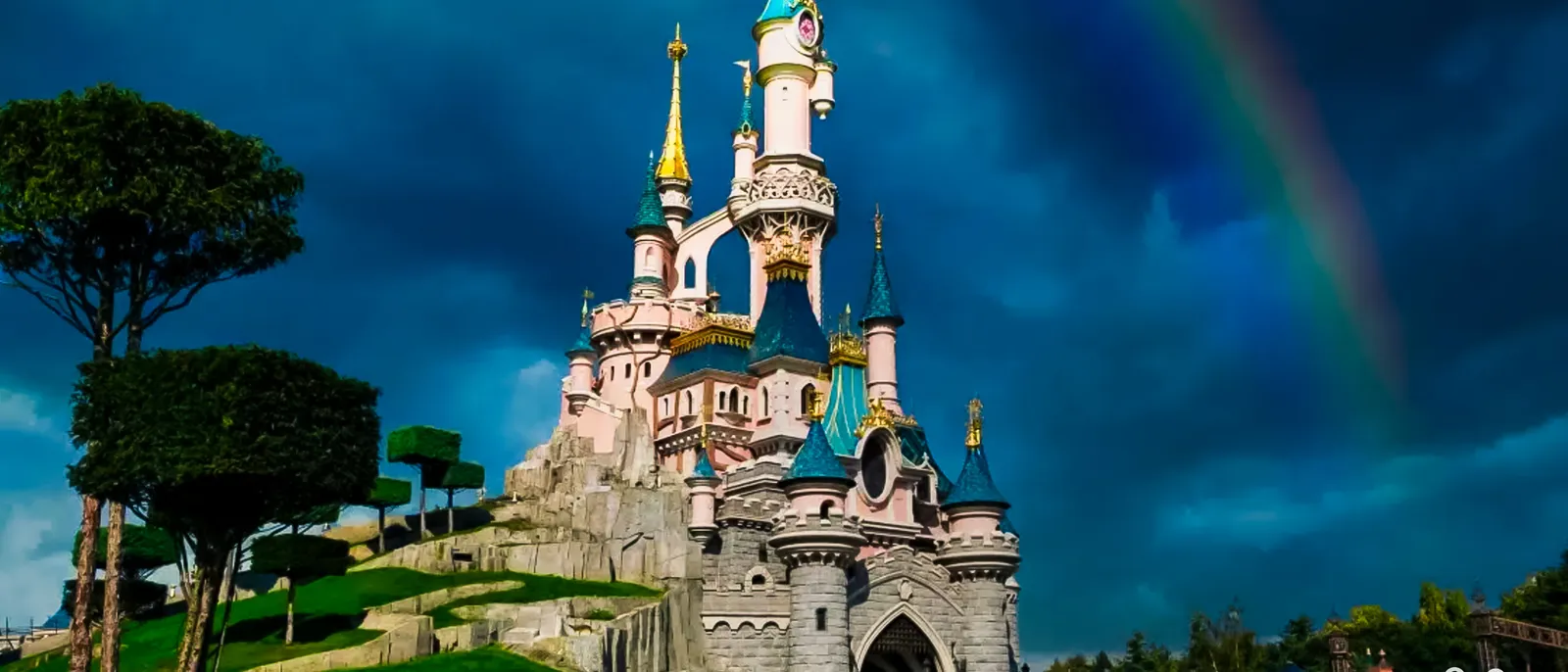 Un arc-en-ciel traverse le ciel orageux au-dessus du château de la Belle au Bois Dormant, à Disneyland Paris