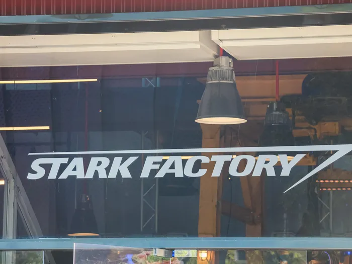 Logo Stark Factory inscrit sur la baie vitrée à l’entrée du restaurant, Avengers Campus