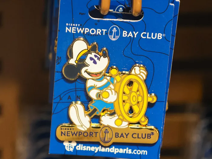 Pin of Mickey as a captain holding a gold ship’s wheel, on a Newport Bay Club card.