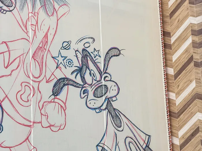 Grande bâche dessinée de Dingo étourdi et de ballons de foot sur la façade bois du Sports Bar & Lounge, Disney Village.