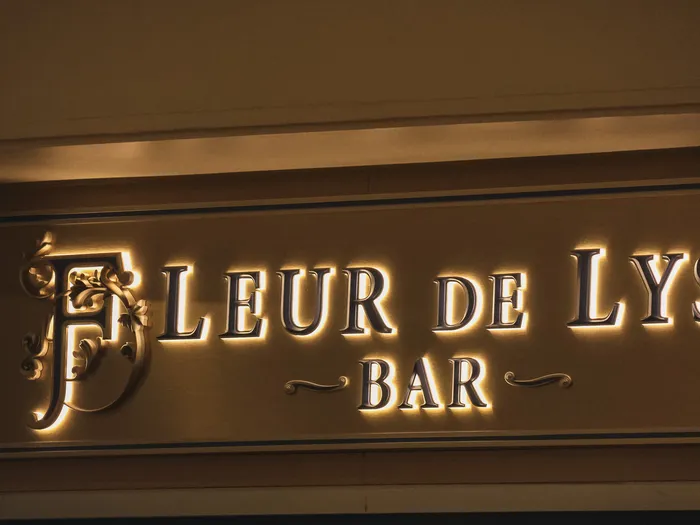 Enseigne dorée et lumineuse « Fleur de Lys Bar » ornée de fleurs de lys, au Disneyland Hotel