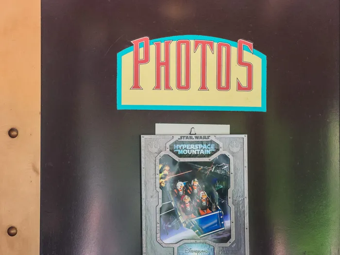 "Photos" sign and frame of the Star Wars Hyperspace Mountain ride photo on display in the Light Speed Photography shop at Disneyland Paris.