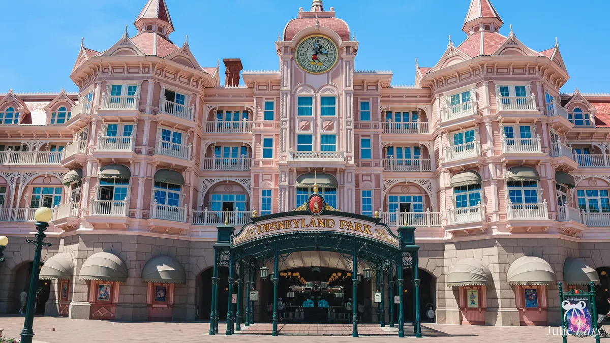 Disneyland Park entrance beneath the Disneyland Hotel, where the annual pass ticket windows are: pink facade, Mickey clock and green canopy