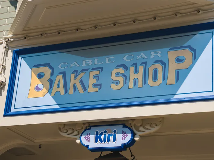 Enseigne peinte bleue Cable Car Bake Shop au-dessus de la vitrine du restaurant sur Main Street USA.