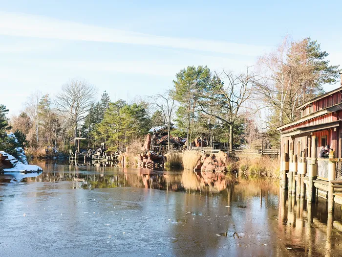 Rivière gelée et bâtiment rouge de l’embarcadère Thunder Mesa Riverboat Landing sous un ciel bleu hivernal
