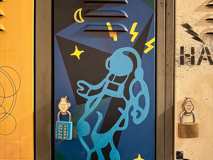 Casier « M. Morales » peint d’un astronaute bleu avec cadenas, décor de la file de Spider-Man W.E.B. Adventure.