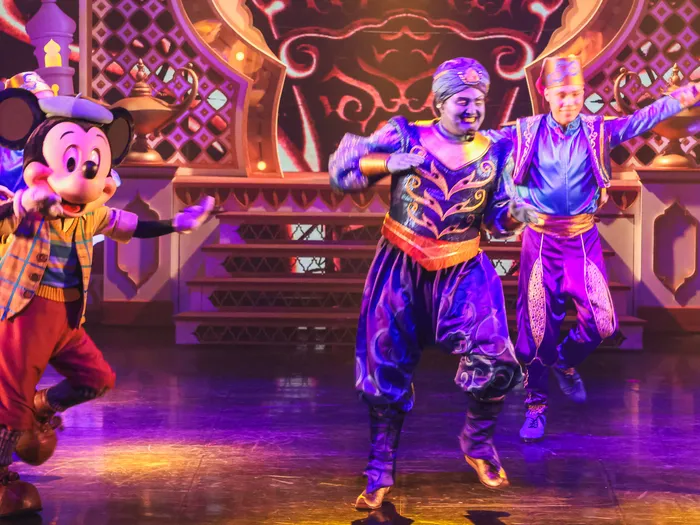 Mickey danse aux côtés du Génie et de danseurs en tenue orientale sur la scène d’Aladdin, spectacle Mickey et le Magicien