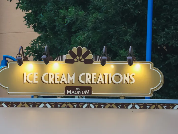 Enseigne dorée lumineuse « Ice Cream Creations » avec logo Magnum du kiosque à glaces