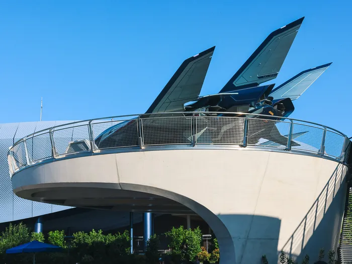 Le Quinjet des Avengers posé sur une plateforme circulaire à Marvel Avengers Campus, sous un ciel bleu.