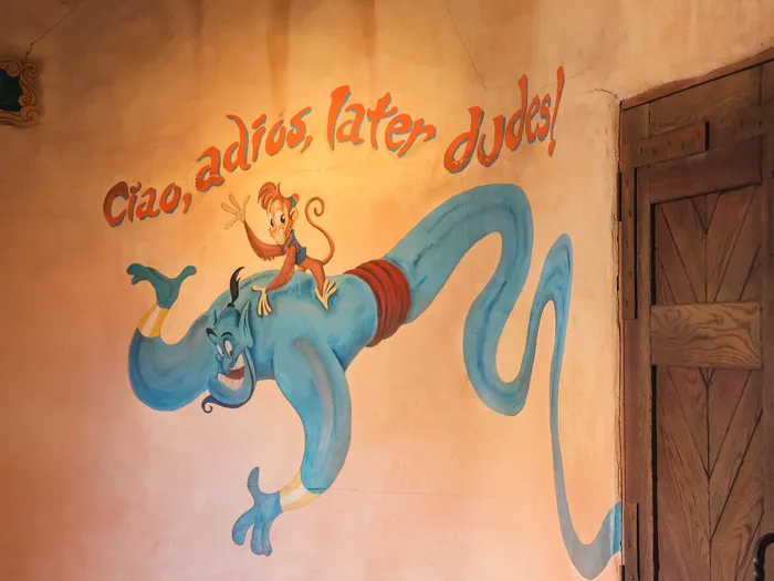 Fresque murale du Génie et du singe Abu avec l’inscription « Ciao, adios, later dudes » au Passage Enchanté d’Aladdin.
