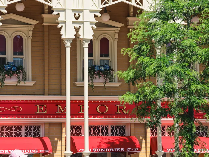 Façade extérieure de l'Emporium à Disneyland Paris, avec ses auvents rouges « Dry Goods, Sundries & Apparel » sur Main Street.
